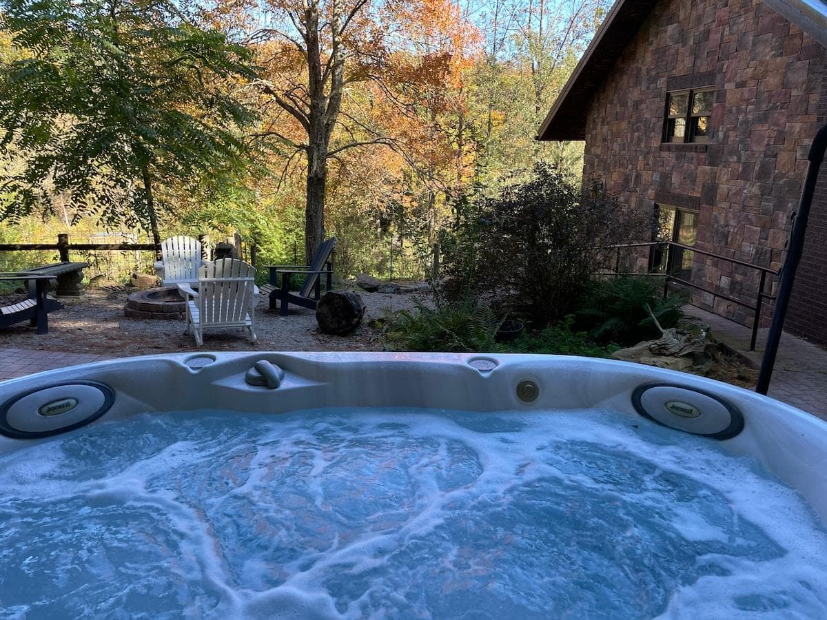 From the bubbly hot tub look out over the fire pit and valley below